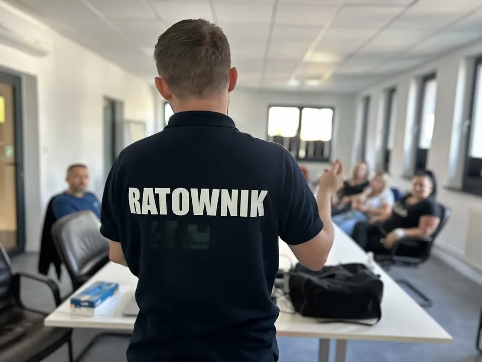 Ratownik mówiący grupie jak udzielać pierwszej pomocy