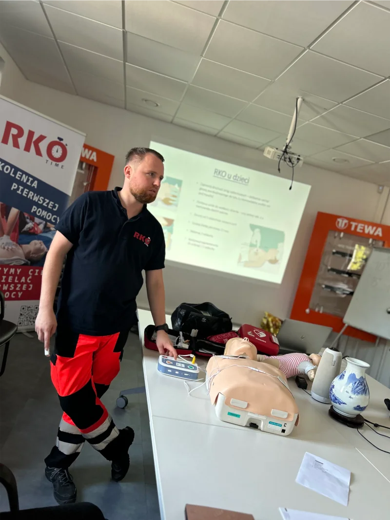 Instruktor pokazuje działanie AED